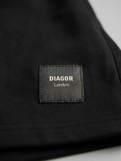 Close up of sewn DIAGOR patch logo on Forge heavyweight men’s sweat shorts in black