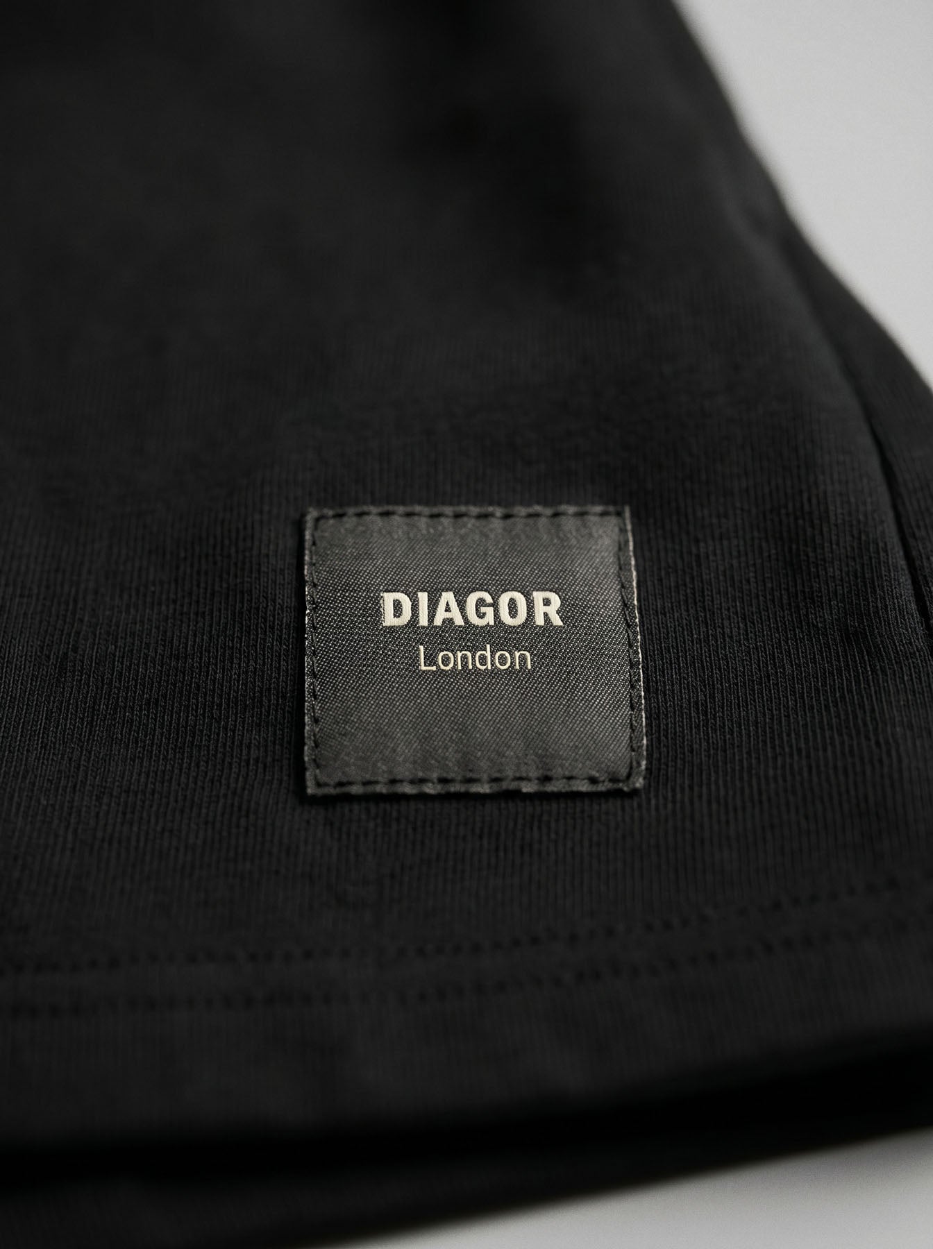 Close up of sewn DIAGOR patch logo on Forge heavyweight men’s sweat shorts in black