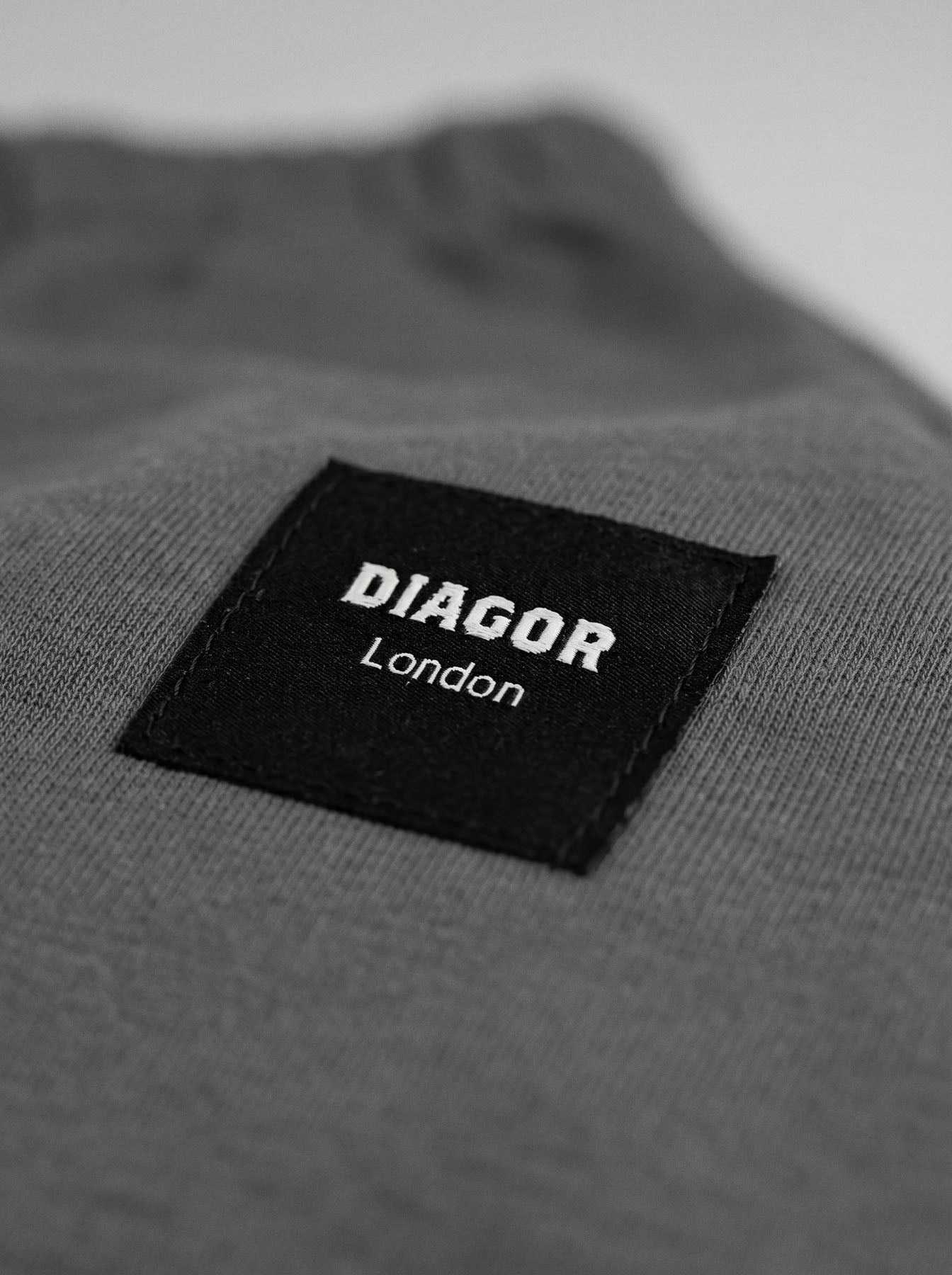 Close up of sewn DIAGOR patch logo on Forge heavyweight men’s sweat shorts in charcoal