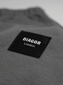 Close up of sewn DIAGOR patch logo on Forge heavyweight men’s sweat shorts in charcoal