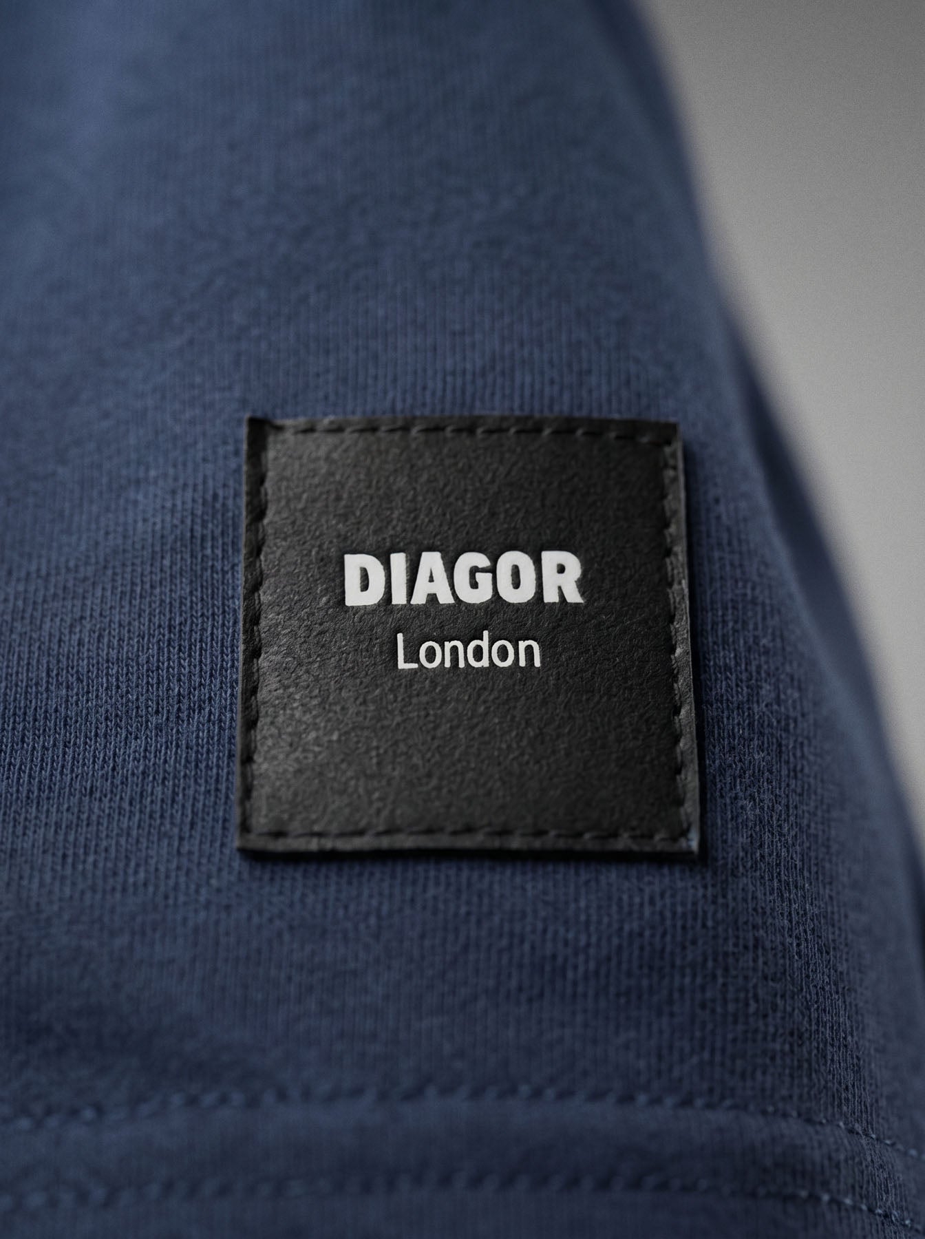 Close up of sewn DIAGOR patch logo on Forge heavyweight men’s sweat shorts in navy