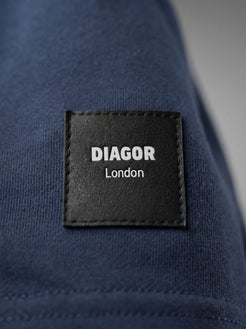 Close up of sewn DIAGOR patch logo on Forge heavyweight men’s sweat shorts in navy
