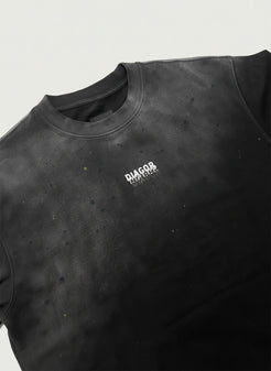 Close up of heavyweight cotton fabric and Diagor logo on Grafted Oversized Men’s T-Shirt in washed black 