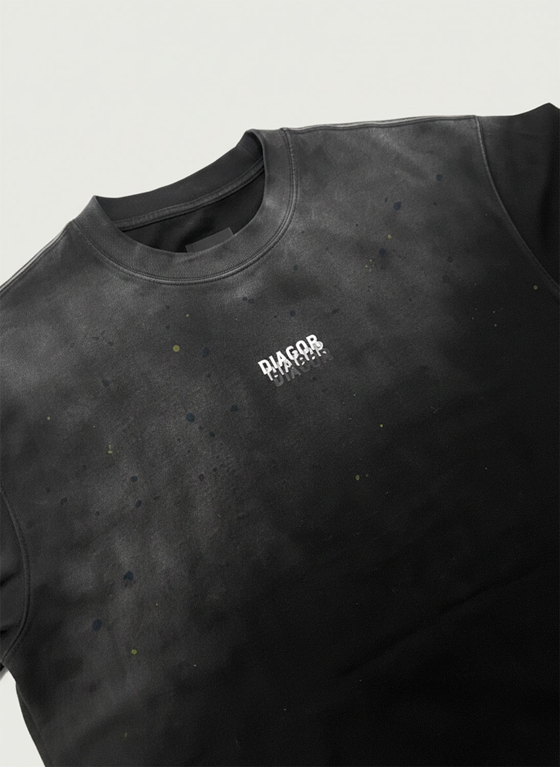 Close up of heavyweight cotton fabric and Diagor logo on Grafted Oversized Men’s T-Shirt in washed black 