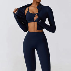 Model wearing Tempo 3-piece women’s training set in navy, sports bra, leggings and zip top